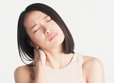 首の痛みに悩む女性